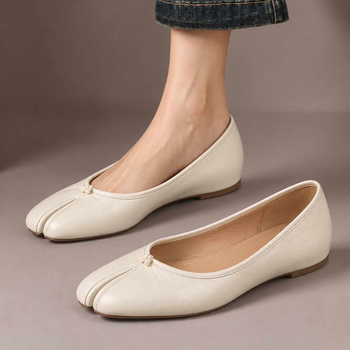 Imogen™ | Split-Toe Ballet Flats — one worn shoe and one matching shoe in a taupe studio
