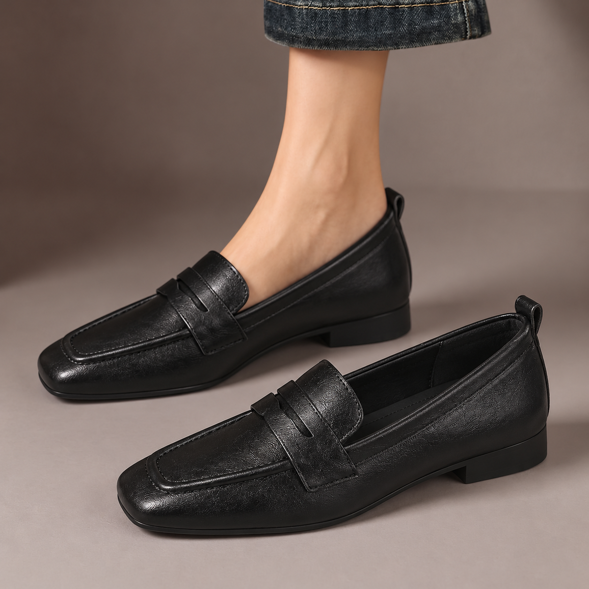 Ottilie™ | Square-Toe Penny Loafers — one worn shoe and one matching shoe in a taupe studio