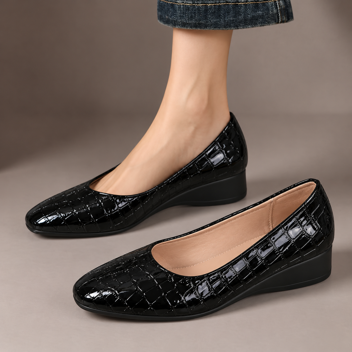 Philippa™ | Glossy Low-Wedge Pumps — one worn shoe and one matching shoe in a taupe studio